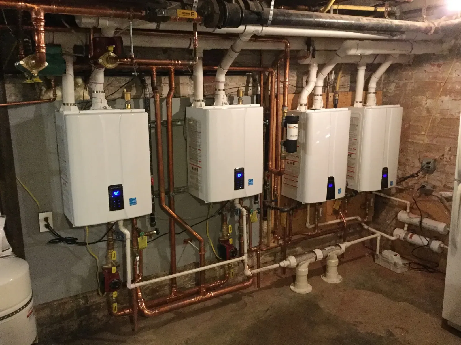 Four wall-mounted tankless units installed by Mallick Plumbing & Heating