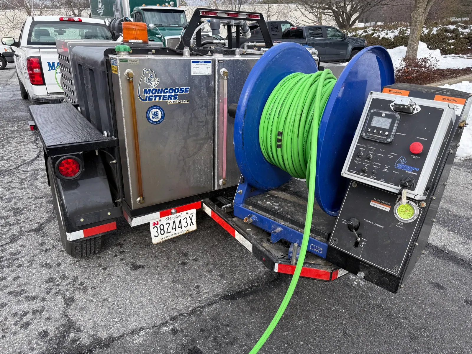 Mallick hydro-jetting trailer with a green hose reel and control panel
