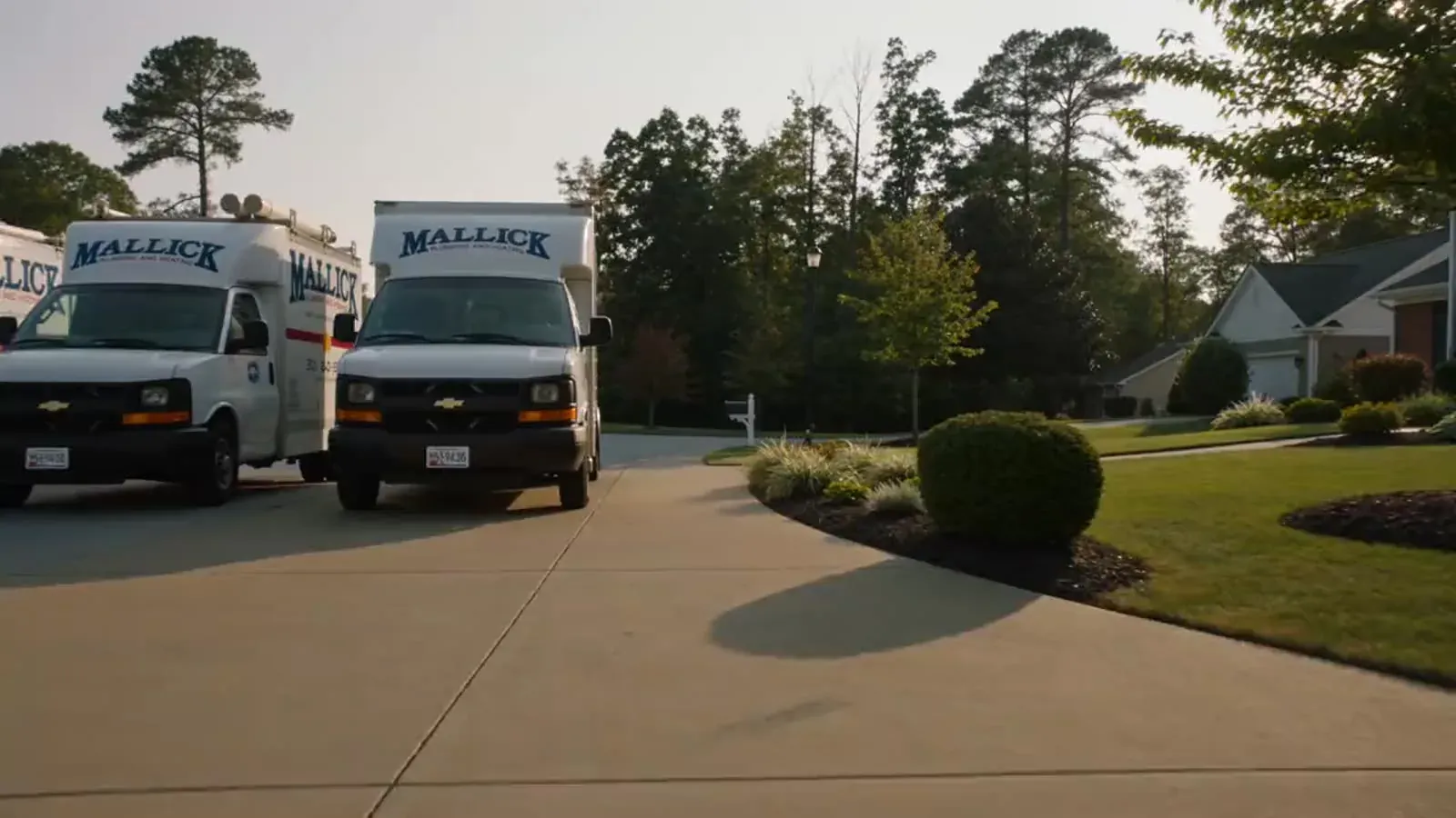 A Mallick Plumbing and Heating technician arriving at a Maryland home with a tool bag