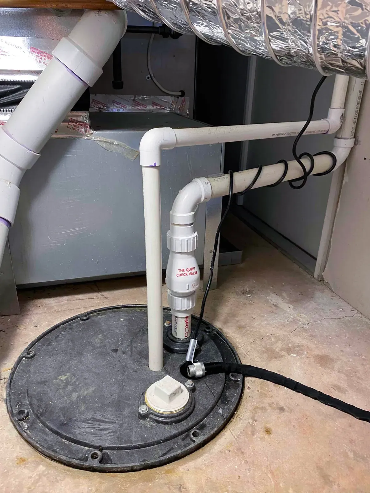 Sump pump installation with a sealed basin and PVC discharge piping by Mallick Plumbing & Heating